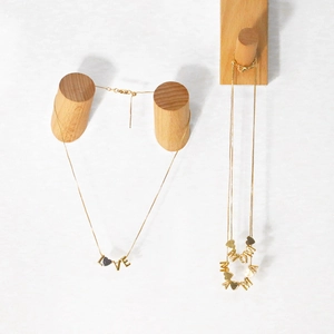 Detailed view of gold Love and Mama letter pendants with heart motifs on fine chains
