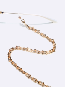 Detailed macro view of a gold U-link chain for eyewear with anti-slip rubber loops
