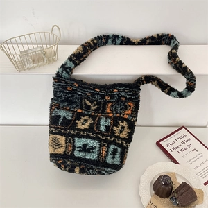 Close-up of plush bucket bag with colorful geometric patterns on white stairs