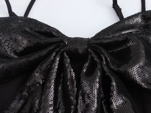 Détail d'un nœud 3D à paillettes noires sur le haut court montrant texture et éclat