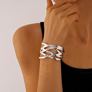 Macro detail of high-polish silver geometric crossover open cuff bracelet for women