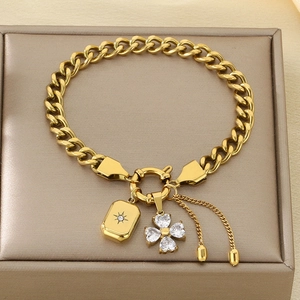 Detail of gold-plated cuban chain bracelet featuring zircon clover and star pendants