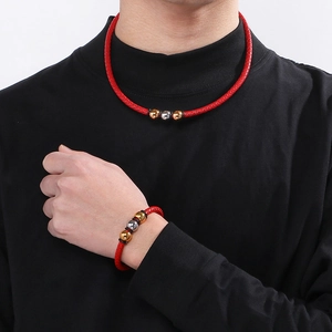 Detail of red braided leather necklace and bracelet set with gold and silver metal beads
