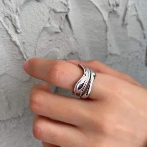 Detail view of irregular 925 sterling silver ring on finger with fluid line design