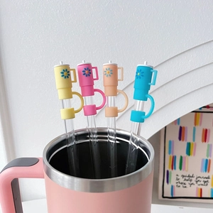 Close-up of colorful daisy silicone straw covers on glass straws with thermal tumbler