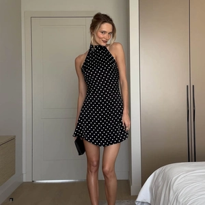 Détail d'une robe courte dos nu à pois noirs chic avec une coupe trapèze élégante