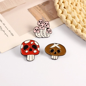 Three creative mushroom skull enamel pins made of alloy metal on a neutral background