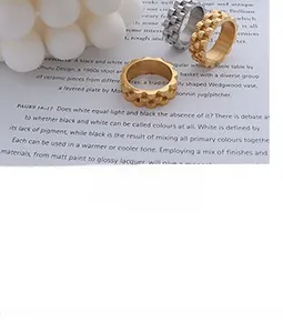 Industrial style gold and silver gear textured rings on a minimalist magazine background