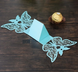 Detail of laser-cut sky blue butterfly favor box showing delicate wing patterns and fold