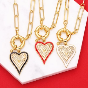 Trois colliers à maillons dorés avec pendentifs cœur en émail noir, rouge et blanc