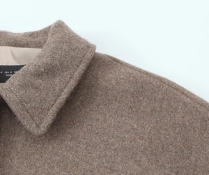 Macro view of the collar and wool texture on this coffee brown short coat with inner labels