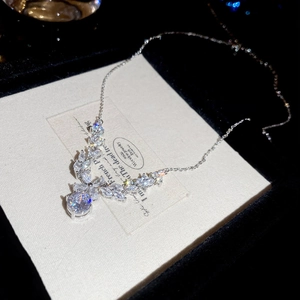 Detailed close-up of a silver zircon floral pendant necklace on a black velvet display