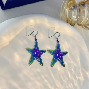 Macro detail of rainbow starfish earrings with ocean-themed gradient metal texture