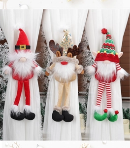 Three plush Christmas curtain tiebacks featuring Santa, reindeer, and an elf on white curtains