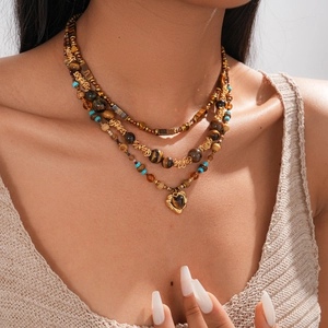 Close-up of three-layer beaded heart necklace with tiger eye stones on model