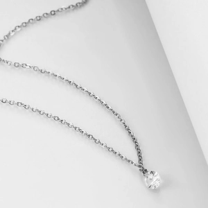 Macro shot of 6mm silver necklace featuring a sparkling solitaire gemstone and claw setting
