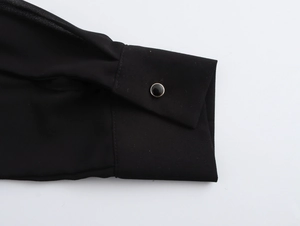 Detailed close-up of a black chiffon sleeve cuff with a single round button closure