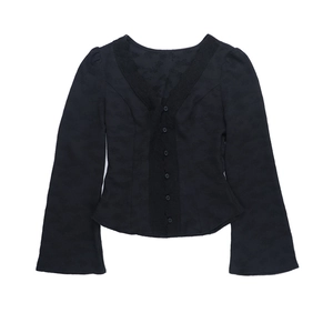 Détail d'un cardigan noir à col en V avec dentelle, texture fleurie et manches évasées