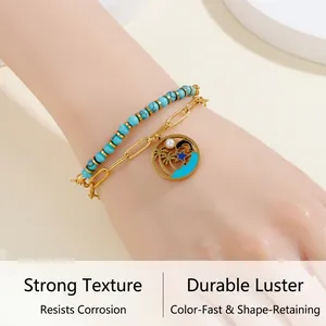 Détail d'un bracelet double couche en turquoise avec breloque palmier doré et perle