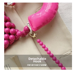 Dettaglio borsa di perle rosa acceso con chiusura a moschettone dorata e tracolla in tessuto