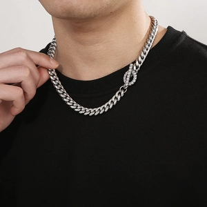 Detail of silver Cuban link chain with sparkling rhinestone-set OT clasp on male model