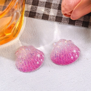 Detail of pink resin starfish and shell charms with glitter for DIY hair clip accessories