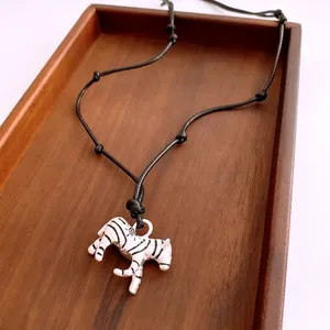 Minimalist zebra pendant necklace with black enamel stripes on adjustable cord string