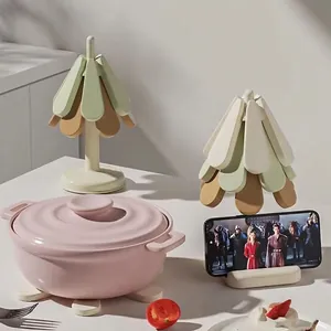 Green foldable silicone trivet resistant to 150°C and usable as a phone stand