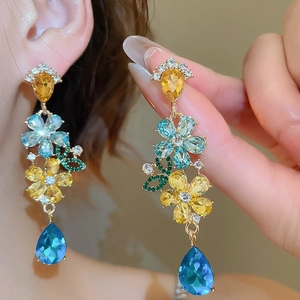Detail of colorful floral crystal drop earrings in yellow, blue and green gems