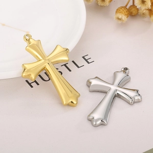 Détail de pendentifs croix en or et argent pour hommes sur un plat décoratif blanc