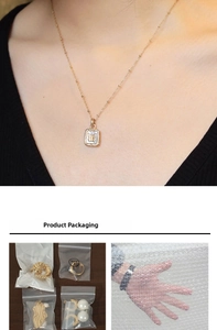 Détail du collier pendentif papillon doré avec breloque en nacre et emballage de protection