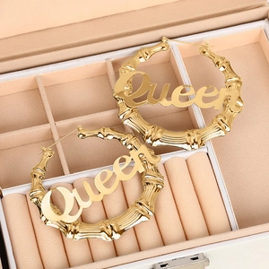 Makro-Detail der goldenen Queen-Creolen mit Bambus-Textur in einer Schmuckschatulle präsentiert