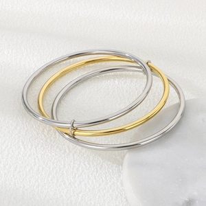 Close-up of interlocked 3mm round wire bangles in polished silver and gold finish