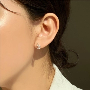 Detail of 925 sterling silver geometric square zircon earrings worn on a model ear