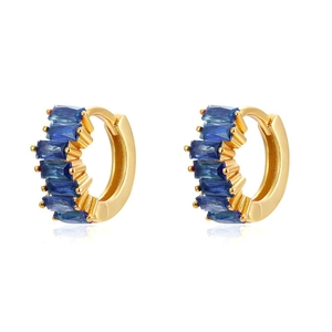 Detalle de pendientes de aro dorados en C con circonitas azules rectangulares engastadas