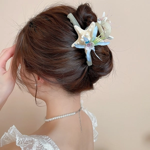 Detailed back view of a starfish floral hair clip styled in an elegant updo