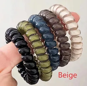 Close-up of flexible spiral hair ties in black, olive, navy, coffee, and beige colors
