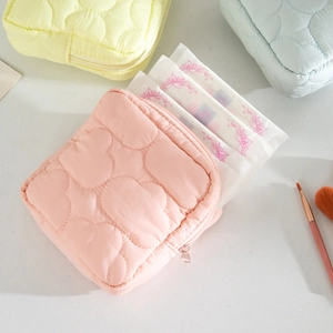 Detailed view of quilted pastel pouches showing cloud textures and smooth zipper
