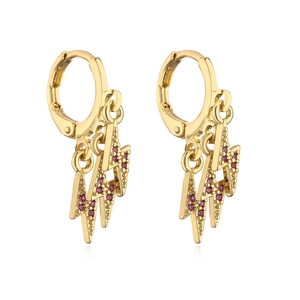 Close-up of gold lightning bolt earrings with three red zircon stone pendants