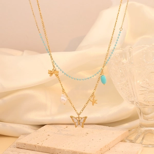 Close-up of double-layer gold necklace with butterfly, starfish and turquoise beads