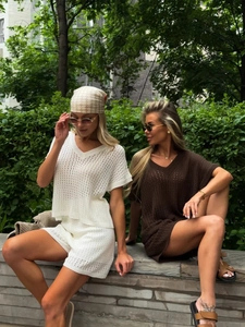 Gros plan sur l'ensemble en maille crochetée blanche avec col en V et détails ajourés