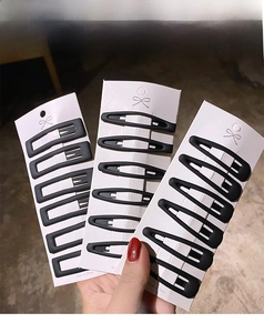 Close-up of matte black hair clips set in rectangle and oval shapes on display cards