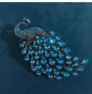 Macro shot of blue crystal peacock brooch with intricate rhinestone details and alloy base