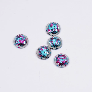 Five round clear resin cabochons with pink and blue glitter fill on white background