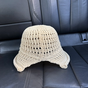 Close-up of beige hollow knit sun hat featuring breathable crochet texture and rolled edge