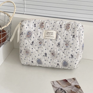Detailed macro view of quilted makeup bag with bear patterns and blue stripes