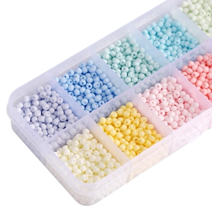 Macro shot of macaron colored glass seed beads organized in a clear plastic storage box