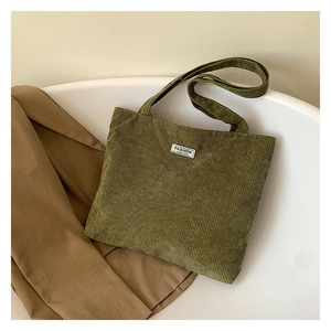 Detail shot of green corduroy tote bag texture with Fashion Instinct white woven label