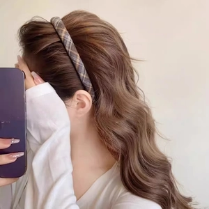 Woman wearing vintage brown plaid headband for preppy style with wave curls