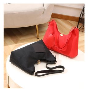 Close-up of red and black quilted nylon tote bags with wavy patterns and zippers
